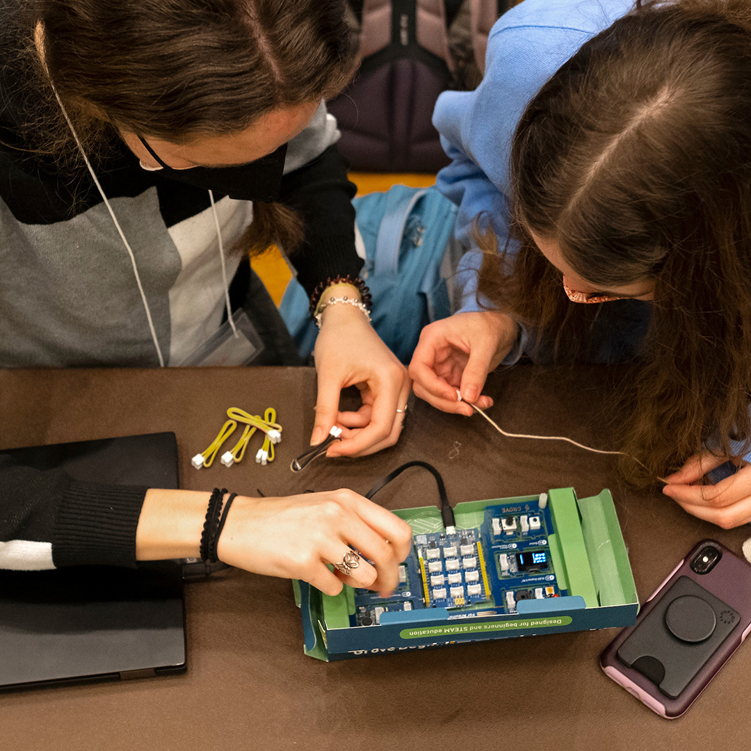 two students work on a circuit board